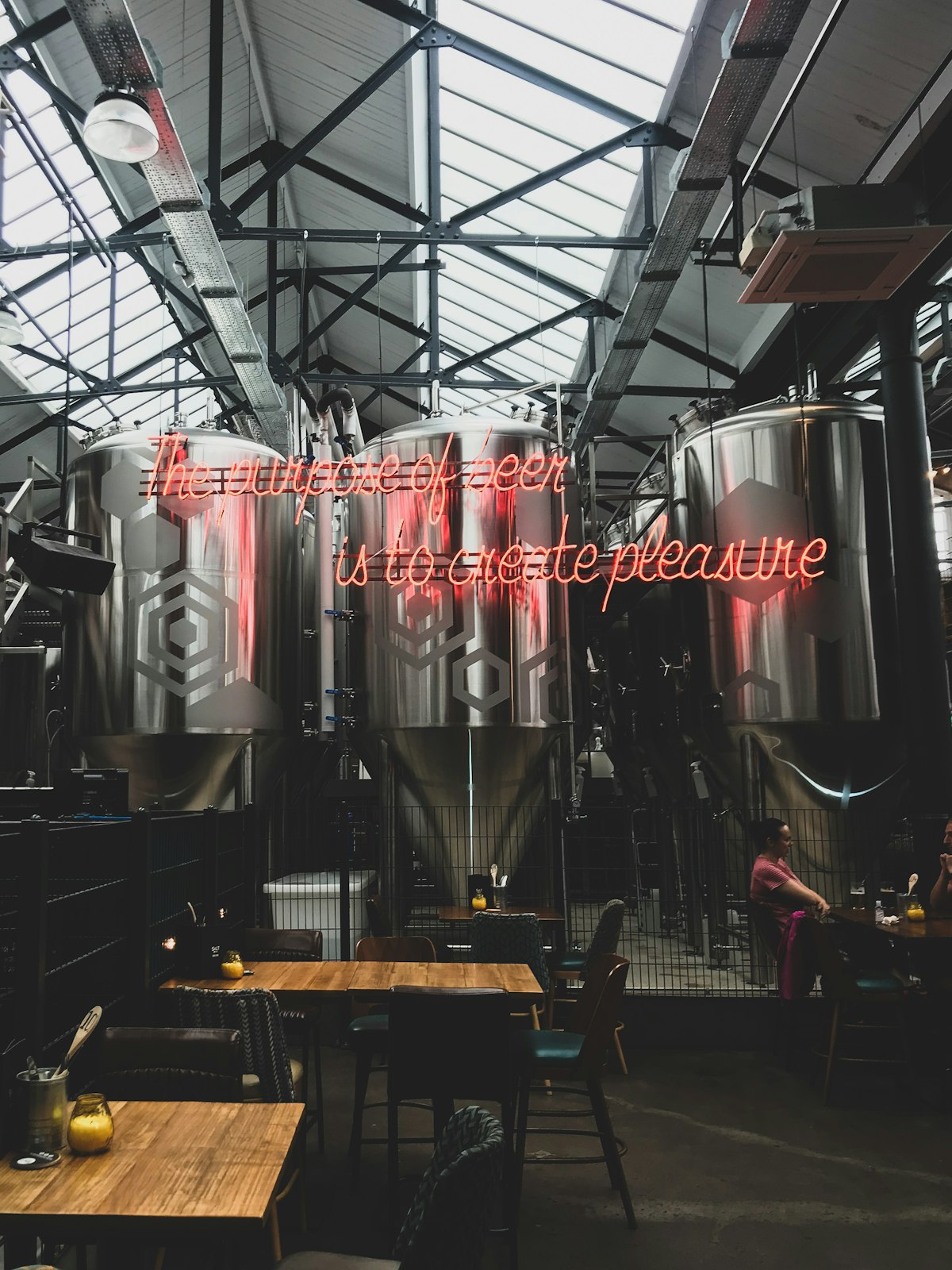 Industrieller Taproom mit großen Sudkesseln aus Stahl unter einem Werkshallendach
