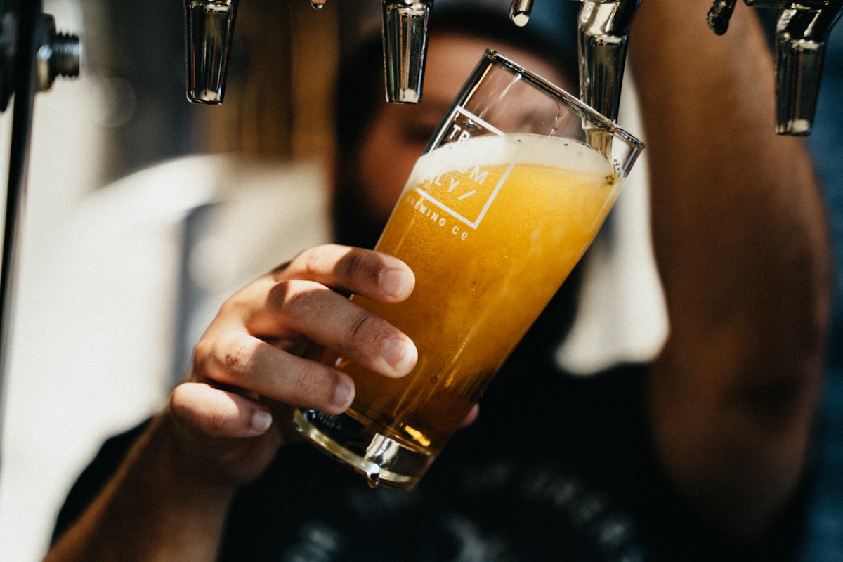 Frisch gezapftes, trübes Bier läuft am Zapfhahn ins Glas